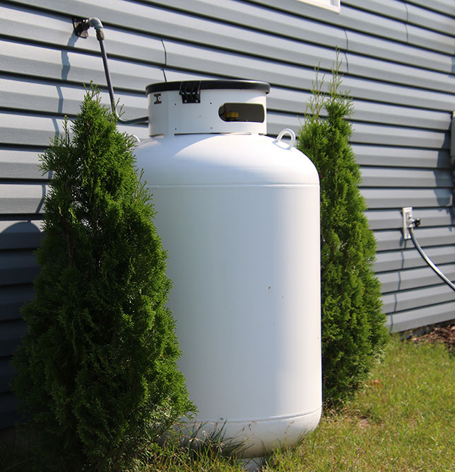 Small propane tank against a house outside